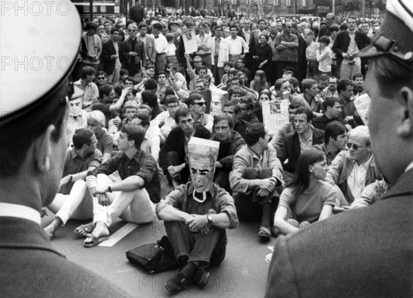 Sit-down strike demonstrators being watched by police officers in front of the town hall Schöneberg in Berlin on 2nd June 1967