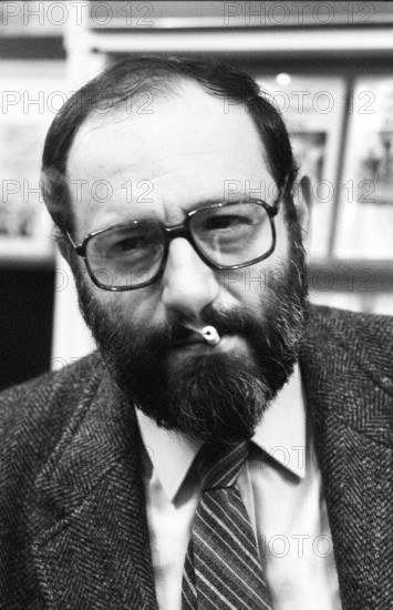 Umberto Eco (Schriftsteller) 10/83 ru Umberto Eco bei der Frankfurter Buchmesse im Oktober 1983 Mann Italien Italiener Autor Schriftstellerei Literatur Medien Medienwissenschaftler Semiotiker Semiotik Postmoderne Romane Epik "Der Name der Rose" dunkelhaarig kurzhaarig Bart bärtig Vollbart Brille Brillenträger seriös Anzug Hemd Jackett Krawatte sitzen sitzend Zigarette im Mund rauchen rauchend Messe Buch Bücher Frankfurt Regale Bücherregale Ausstellung Hochformat hoch Portrait halb sw