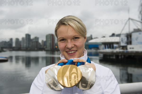Eisschnelllaeuferin Stephanie BECKERT, GER, zeigt Ihre drei Medaillen, eine Goldmedaille und zwei Silbermedaillen, Olympiasiegerin, Portraet, Portrait, vor der Skyline von Vancouver, Fotoshooting, Eisschnelllaufen der Damen Frauen, am 28.02.2010 XXI. Olympische Winterspiele 2010, vom 12.02. - 28.02.2010 in Vancouver/ Kanada.
