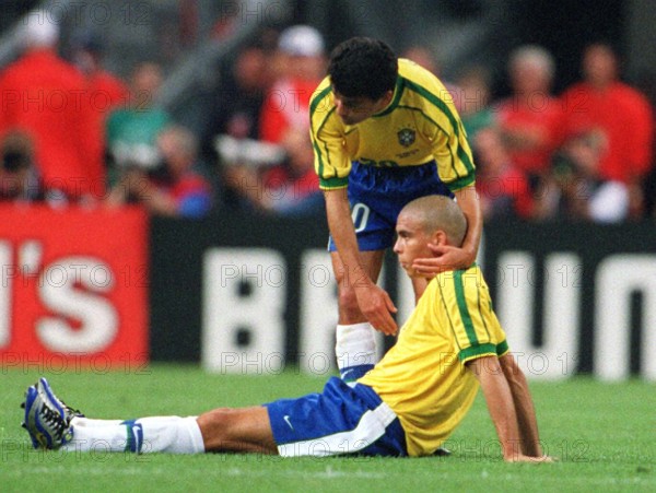 Brazilian forward Bebeto (standing) comforts his teammate Ronaldo after the 1998 World Cup final France against Brazil at the Stade de France in Saint Denis, Paris, France, 12 July 1998. France won the game 3-0 (2-0)against titleholder Brazil and won the world championship title for the first time.