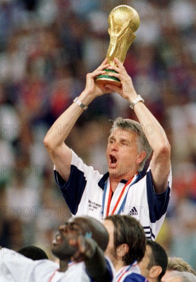French soccer coach Aime Jacquet cheers and laughs while he holds the World Cup trophy in his hands after the 1998 World Cup final France against Brazil in Paris, France, 12 July 1998. France won the game 3-0 against titleholder Brazil and won the world champion title for the first time.
