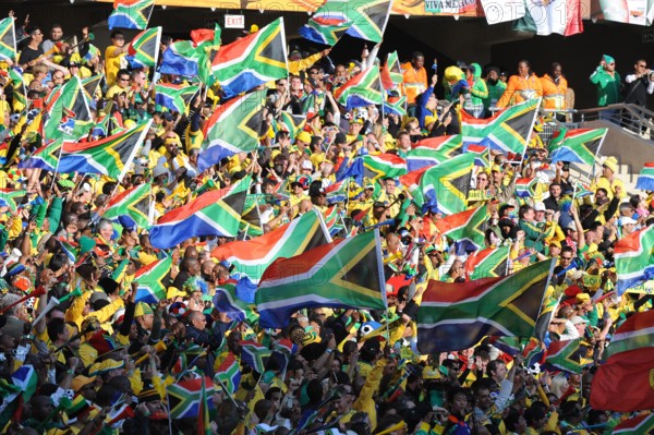 South African supporters wave flags during the opening match between South Africa and Mexico at the 2010 FIFA World Cup at Soccer City stadium in Johannesburg, South Africa 11 June 2010. Photo: Achim Scheidemann dpa - Please refer to http://dpaq.de/FIFA-WM2010-TC