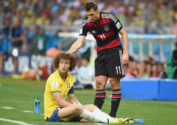 Germany's Miroslav Klose (R) helps up Brazil's David Luiz during the FIFA World Cup 2014 semi-final soccer match between Brazil and Germany at Estadio Mineirao in Belo Horizonte, Brazil, 08 July 2014. Photo: Marcus Brandt/dpa (RESTRICTIONS APPLY: Editorial Use Only, not used in association with any commercial entity - Images must not be used in any form of alert service or push service of any kind including via mobile alert services, downloads to mobile devices or MMS messaging - Images must appear as still images and must not emulate match action video footage - No alteration is made to, and no text or image is superimposed over, any published image which: (a) intentionally obscures or removes a sponsor identification image; or (b) adds or overlays the commercial identification of any third party which is not officially associated with the FIFA World Cup) EDITORIAL USE ONLY +++ dpa-Bildfunk +++