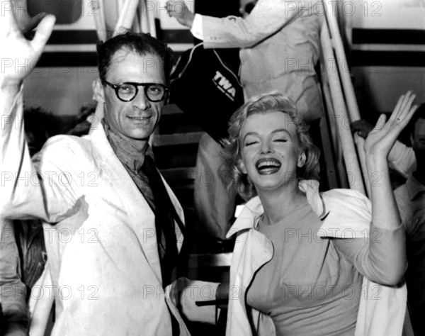Die US-amerikanische Schauspielerin Marilyn Monroe und ihr frischgetrauter Ehemann, der Dramatiker Arthur Miller, winken der Presse zu, bevor sie am 13.7.1956 in New York ein Flugzeug nach Großbritannien, wo sie ihre Flitterwochen verbringen wollen, besteigen. Dies ist Monroes zweite Ehe.