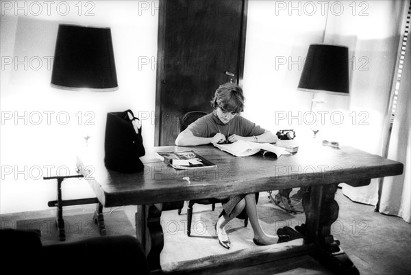Françoise Sagan sitting at her desk