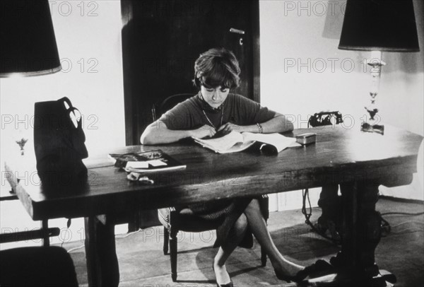 Françoise Sagan sitting at her desk