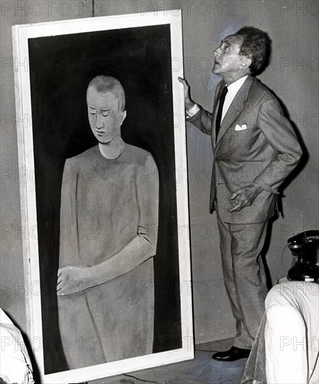 Cocteau accroche une toile chez lui, 1958
