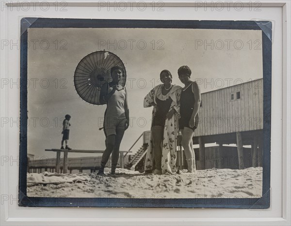 “Ragazze al mare, una con ombrellino"