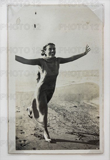 “Donna che corre sulla spiaggia con braccia aperte"