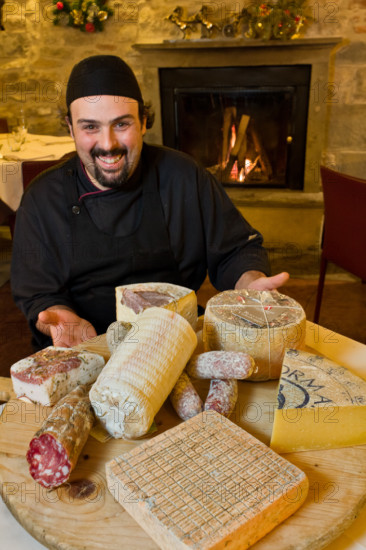 Città alta, Ristorante DAMIMMO: Valerio Veneroni, secondo di cucina, mostra un tagliere di formaggi (roccolo, strachitunt, taleggio, formai de mut) e salumi (pancetta, salame, cacciatori) tipici bergamaschi.
Bergamo (BG), Lombardia, Italia - Italy
