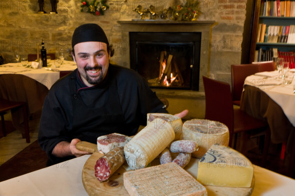 Città alta, Ristorante DAMIMMO: Valerio Veneroni, secondo di cucina, mostra un tagliere di formaggi (roccolo, strachitunt, taleggio, formai de mut) e salumi (pancetta, salame, cacciatori) tipici bergamaschi.
Bergamo (BG), Lombardia, Italia - Italy