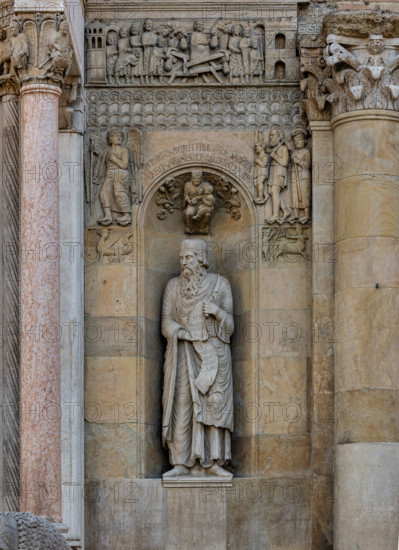 Fidenza, cathedral (Cathedral of San Donnino):
“The Prophet Ezekiel” by Benedetto Antelami.
The prophet holds a scroll that refers to the meaning of the church as the “Gate of Heaven”; it reads: Ezechiel Propheta; vidi portam in domo Domini clausam (Ezekiel Prophet; I saw the door closed in the house of the Lord).
In the dome of the niche is a bas-relief depicting a Madonna and Child surrounded by bunches of flowers and fruit surmounted by an inscription that explains its theological meaning.

On the sides of the niche, always symmetrical with the left part of the façade, we see two small panels depicting a harpy and a centaur striking a deer, and, higher up, the figure of an Angel presumably intent on indicating the road of the Via Francigena to a family of poor pilgrims.
Above a band decorated with geometric motifs is the bas-relief of the “Miracle of the pregnant woman”.
Cattedrale di S. Donnino, Fidenza (PR), Emilia Romagna, Italia - Italy