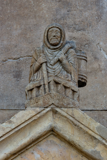 Fidenza, Duomo (Cattedrale di San Donnino), acroterio del portale destro: “Raimondinus vilis”, il Povero Raimondino. In questa figura viene tradizionalmente riconosciuto  San Raimondino Zanfogni, detto Palmerio, di Piacenza (1140 – 27 luglio 1200), un laico che sarebbe stato pellegrino in Terrasanta (da qui il soprannome) e poi a San Giacomo di Campo Stella. Tornato a Piacenza avrebbe assistito e difeso i poveri della sua città e avrebbe fondato un ospedale. 

[ENG]
Fidenza, Duomo (Cathedral of San Donnino), acroterion of the right portal: “Raimondinus vilis”, the Poor Raimondino. This figure is traditionally recognized as Saint Raimondino Zanfogni, called Palmerio, of Piacenza (1140 – 27 July 1200), a layman who was a pilgrim to the Holy Land (hence the nickname) and then to San Giacomo di Campo Stella. Returning to Piacenza, he assisted and defended the poor of his city and founded a hospital.
Cattedrale di San Donnino, Fidenza (PR), Emilia-Romagna, Italia - Italy