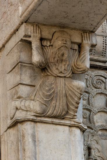 Fidenza, Duomo (Cattedrale di San Donnino), facciata, il portale maggiore,  protiro: telamone di sinistra.

[ENG]
Fidenza, Duomo (St. Donnino Cathedral), the façade, the main portal, the prothyrum: the left telamon.
Cattedrale di San Donnino, Fidenza (PR), Emilia-Romagna, Italia - Italy