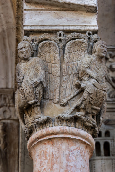 Fidenza, Duomo (Cattedrale di San Donnino), facciata, portale maggiore, protiro: il capitello di destra con “i Quattro Evangelisti”.  A sinistra “S. Marco”; a destra “S. Matteo”  con piedi umani che porta l’iscrizione: LIBER. / [G]ENE / [R]ACI / [ON]NIS. (Liber generationis (Mt 1,1)= Libro della generazione…)
Opera di Benedetto Antelami e bottega.

[ENG]
Fidenza, Duomo (Cathedral of San Donnino), facade, main portal, prothyrum:  the right capital with “the Four Evangelists”. On the left “St. Mark”; on the right “St. Matthew”  with human feet bearing the inscription: LIBER. / [G]ENE / [R]ACI / [ON]NIS. (Liber generationis (Mt 1,1) = Book of the generation…).
Work by Benedetto Antelami and workshop.
Cattedrale di San Donnino, Fidenza (PR), Emilia-Romagna, Italia - Italy