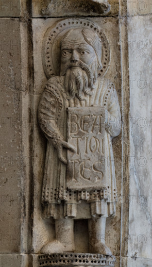 Fidenza, Duomo (Cattedrale di San Donnino), facciata, portale maggiore: dettaglio dell’archivolto con “Allegorie delle Beatitudini”. Apostolo con l’iscrizione: BEA/TI MI/TES = Beati i miti (Mt. 5, 4).
Opera di Benedetto Antelami e bottega.

[ENG]
Fidenza, Duomo (Cathedral of San Donnino), facade, main portal: detail of the archivolt with “Allegories of the Beatitudes”. An apostle with the inscription: BEA/TI MI/TES = Blessed are the meek (Mt. 5, 4).
Work by Benedetto Antelami and workshop.
Cattedrale di San Donnino, Fidenza (PR), Emilia-Romagna, Italia - Italy