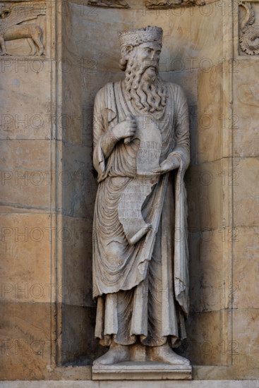 Fidenza, duomo (Cattedrale di San Donnino), sculture tra il portale maggiore e quello di sinistra: la nicchia con il “Re David” di Benedetto Antelami.
Il profeta sorregge un cartiglio sul quale si legge la seguente iscrizione a lettere capitali: DAUID / PPHA / REX / HEC / PORTA / DOMINI / IUSTI: / INTRANT PEREAM (David Propheta Rex – Hec porta Domini iusti intrant per eam [Salmo 118 (117),20]).

[ENG]
Fidenza, duomo (Cathedral of San Donnino), sculptures between the main portal and the left one: the niche with “King David” by Benedetto Antelami.
The prophet holds a scroll on which the following inscription can be read in capital letters: DAUID / PPHA / REX / HEC / PORTA / DOMINI / IUSTI: / INTRANT PEREAM (David Propheta Rex – Hec porta Domini iusti intrant per eam [Psalm 118 (117),20]).
Cattedrale di San Donnino, Fidenza (PR), Emilia-Romagna, Italia - Italy