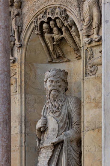 Fidenza, duomo (Cattedrale di San Donnino), sculture tra il portale maggiore e quello di sinistra: la nicchia con il “Re David” di Benedetto Antelami.
Il profeta sorregge un cartiglio sul quale si legge la seguente iscrizione a lettere capitali: DAUID / PPHA / REX / HEC / PORTA / DOMINI / IUSTI: / INTRANT PEREAM (David Propheta Rex – Hec porta Domini iusti intrant per eam [Salmo 118 (117),20]).
Lo sguardo di Re David è rivolto a chi entra nella cattedrale dal portale maggiore.

[ENG]
Fidenza, duomo (Cathedral of San Donnino), sculptures between the main portal and the left one: the niche with “King David” by Benedetto Antelami.
The prophet holds a scroll on which the following inscription can be read in capital letters: DAUID / PPHA / REX / HEC / PORTA / DOMINI / IUSTI: / INTRANT PEREAM (David Propheta Rex – Hec porta Domini iusti intrant per eam [Psalm 118 (117),20]).
King David's gaze is directed at those entering the cathedral from the main portal.
Cattedrale di San Donnino,...