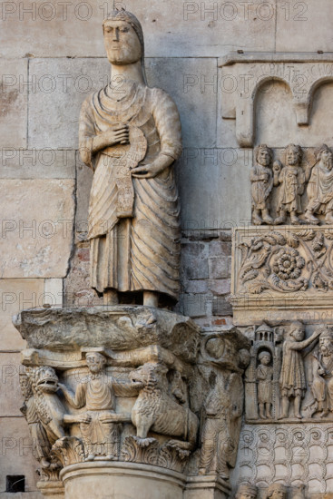 Fidenza, cathedral (Cathedral of San Donnino), sculptures between the main portal and the left one:
Detail of “Saint Simon the Apostle showing the way to Rome to pilgrims”; the statue holds in his hands a phylactery that unfolds downwards on which the inscription is engraved in capital letters: S.IMO / APLS / EUDI / ROMA / SCDS / MON / A[…]RAT / HAC / VIAM (Simon Apostolus eundi Romam demonstrat hanc viam).
The statue surmounts the capital with “Daniel in the lions’ den”.
Work by Benedetto Antelami and workshop.
Cattedrale di San Donnino, Fidenza (PR), Emilia-Romagna, Italia - Italy