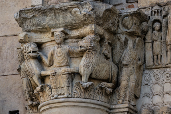 Fidenza, cathedral (Cathedral of San Donnino), sculptures between the main portal and the left one:
Detail of the capital with “Daniel in the lions’ den”. The figurative semi-capital that depicts on the front the biblical scene – of Christological symbolism – of the prophet Daniel who, thrown into the den, is surrounded by tamed lions. On the right side of the semi-capital is depicted the prophet Habakkuk with food for Daniel and on the left side the angel who brought him (Dn 14,33-38). On the abacus of the semi-capital is engraved in capital letters the inscription: […]C DANIEL IVSTUS INLA EST CV LEONV[M] ([Abacu]c . Daniel iustus in lacu est cum leonum).
Work by Benedetto Antelami and workshop.
Cattedrale di San Donnino, Fidenza (PR), Emilia-Romagna, Italia - Italy