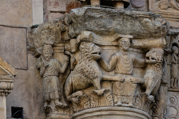 Fidenza, cathedral (Cathedral of San Donnino), sculptures between the main portal and the left one:
Detail of the capital with “Daniel in the lions’ den”. The figurative semi-capital that depicts on the front the biblical scene – of Christological symbolism – of the prophet Daniel who, thrown into the den, is surrounded by tamed lions. On the right side of the semi-capital is depicted the prophet Habakkuk with food for Daniel and on the left side the angel who brought him (Dn 14,33-38). On the abacus of the semi-capital is engraved in capital letters the inscription: […]C DANIEL IVSTUS INLA EST CV LEONV[M] ([Abacu]c . Daniel iustus in lacu est cum leonum).
Work by Benedetto Antelami and workshop.
Cattedrale di San Donnino, Fidenza (PR), Emilia-Romagna, Italia - Italy