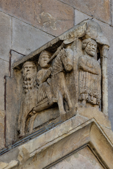 Fidenza, duomo (Cattedrale di San Donnino), portale sinistro, timpano. 
Nell’acroterio sul timpano, é raffigurato un personaggio, probabilmente Oberto II Pallavicino condottiero posto da Federico II di Svevia alla guida della città dal 1249 al 1268. Al suo fianco due suonatori di tromba a cavallo.
Opera di Benedetto Antelami e bottega.

[ENG]
Fidenza, duomo (Cathedral of San Donnino), left portal, tympanum. 
In the acroterion on the tympanum, a character is depicted, probably Oberto II Pallavicino, a leader placed by Frederick II of Swabia at the helm of the city from 1249 to 1268. At his side there are two trumpet players on horseback.
Work by Benedetto Antelami and workshop.
Cattedrale di San Donnino, Fidenza (PR), Emilia-Romagna, Italia - Italy