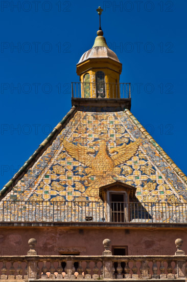 Palermo, Palazzo Reale o Palazzo dei Normanni:  Torre di Porta Nuova. In evidenza, la copertura piramidale rivestita da piastrelle policrome maiolicate con l'immagine di un'aquila ad ali spiegate, progettata dall'architetto Gaspare Guercio nel 1663. 

[ENG]
Palermo, The Royal Palace or Palazzo dei Normanni (Palace of the Normans): the Porta Nuova Tower and its pyramidal roof covered with polychrome majolica tiles with the image of an eagle with spread wings, designed by the architect Gaspare Guercio in 1663.
Palazzo Reale (Palazzo dei Norma, Palermo (PA), Sicilia - Sicily, Italia - Italy