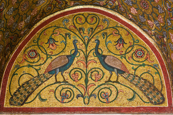 Palermo, Palazzo Reale o Palazzo dei Normanni, Torre Pisana, Sala di Re Ruggero: mosaici della sala voluta da Re Ruggero II d'Altavilla. E' caratterizzata da ampie superfici a mosaico di grande pregio raffiguranti elementi vegetali e scene di carattere aulico e venatorio, simboli del potere normanno (battute di caccia con arcieri e cervi, rappresentati pavoni, cigni, oltre i mitologici centauri, grifi e altri animali esotici  fra lussureggiante vegetazione). I mosaici sono di stile greco - bizantino (secolo XIII).
Particolare di lunetta con pavoni. 

[ENG]
Palermo, The Royal Palace or Palazzo dei Normanni (Palace of the Normans), Pisana Tower,  the King Roger Room: view of the Room which was commissioned by King Roger II d'Altavilla. It is characterized by large mosaic surfaces of great value representing plant elements  and scenes of courtly and hunting style, symbols of the Norman power (hunting scenes with archers and deer, peacocks, swans, and mythological centaurs, griffins an...