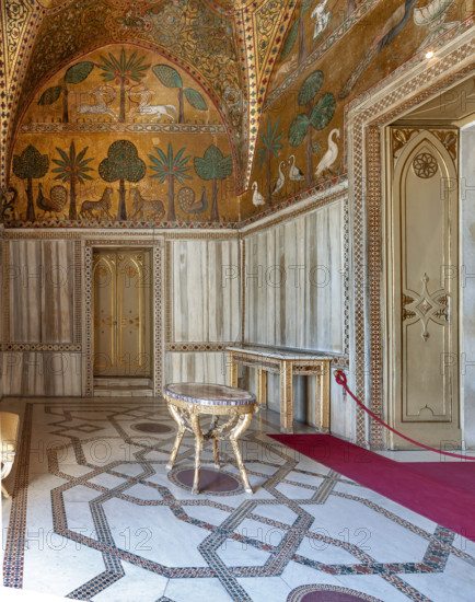 Palermo, Palazzo Reale o Palazzo dei Normanni, Torre Pisana, Sala di Re Ruggero: veduta della sala voluta da Re Ruggero II d'Altavilla. E' caratterizzata da ampie superfici a mosaico di grande pregio raffiguranti elementi vegetali (palme e banani) e scene di carattere aulico e venatorio, simboli del potere normanno (battute di caccia con arcieri e cervi, rappresentati pavoni, cigni, oltre i mitologici centauri, grifi e altri animali esotici tra cui leopardi e tigri fra lussureggiante vegetazione). I mosaici sono di stile greco - bizantino (secolo XIII).

[ENG]
Palermo, The Royal Palace or Palazzo dei Normanni (Palace of the Normans), Pisana Tower,  the King Roger Room: view of the Room which was commissioned by King Roger II d'Altavilla. It is characterized by large mosaic surfaces of great value representing plant elements (palms and banana trees) and scenes of courtly and hunting style, symbols of the Norman power (hunting scenes with archers and deer, peacocks, swans, and mytholo...