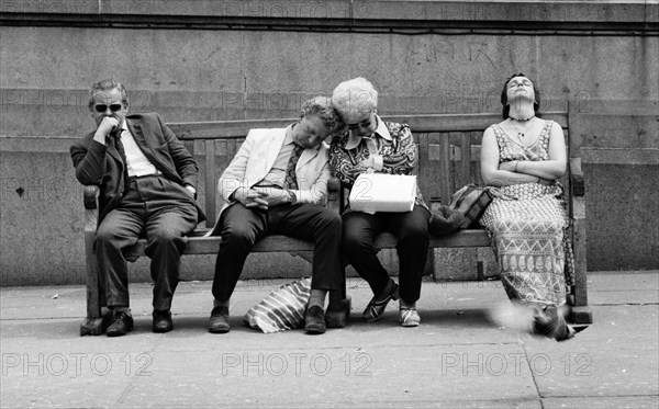 Four People Resting on Street Bench