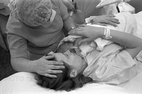 Hospital Nurse Attending Mother With Newborn Baby