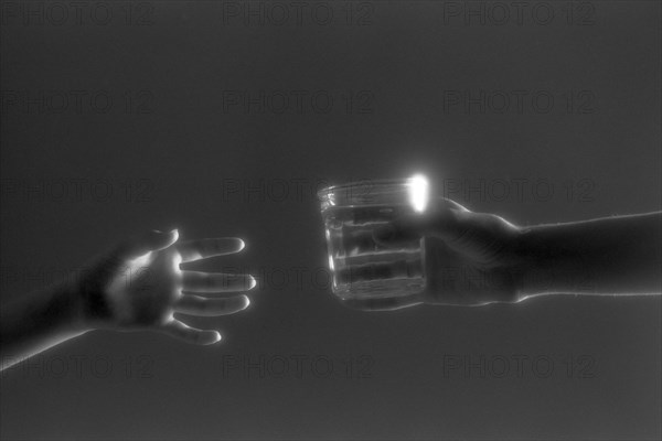Hands Passing Glass of Water