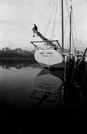 Sailor Adjusting Rigging on Sailboat