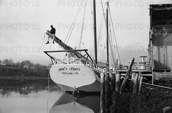 Sailor Adjusting Rigging on Sailboat