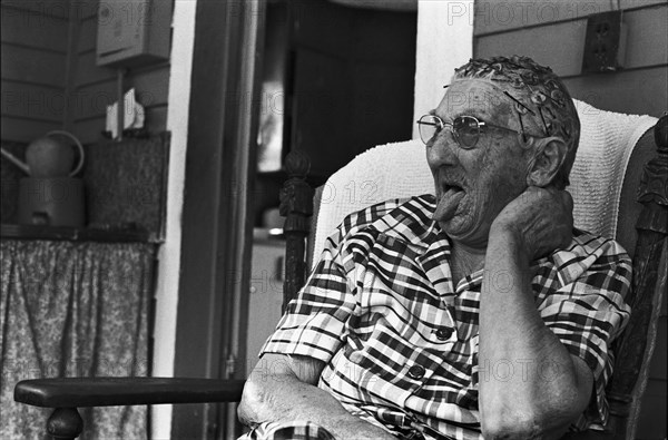 Elderly Woman Sitting on Porch and Sticking Tongue Out