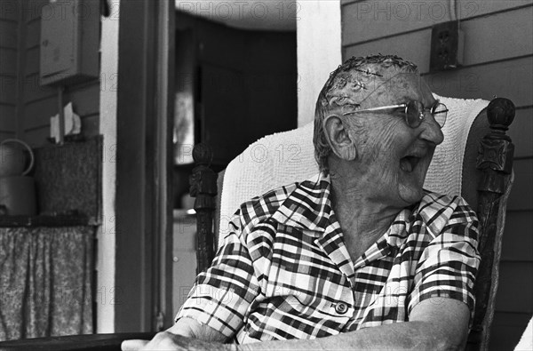 Elderly Woman Sitting on Porch Laughing