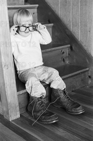 Young Boy Wearing Adult Eyeglasses and Boots