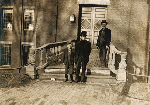 Young Boy Going to Work as Sweeper at Textile Mill at 5:30am, Boy is Illiterate and is Brought to and From Work by His Father (right) Every Day, Lewiston, Maine, USA, Lewis Hine, 1909