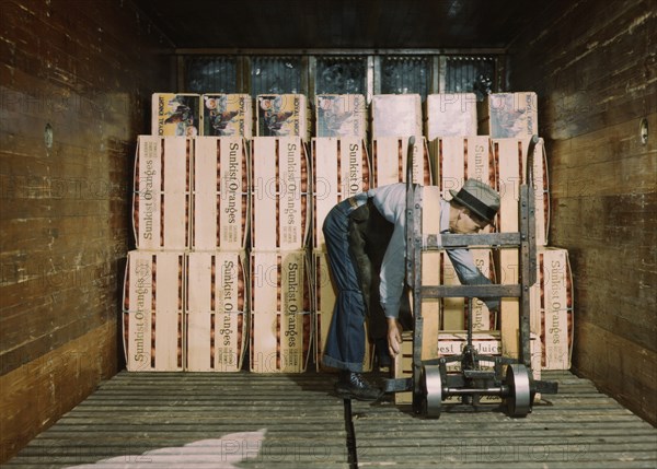 Worker Loading Oranges into Refrigerator Car at a Co-op Orange Packing Plant, Redlands, California, USA, Jack Delano for Farm Security Administration, 1943