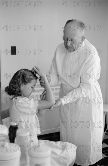 Doctor Examines Young Girl's Fractured Arm, Farm Security Administration (FSA) Camp Clinic, Weslaco, Texas, USA, Arthur Rothstein for Farm Security Administration, February 1942