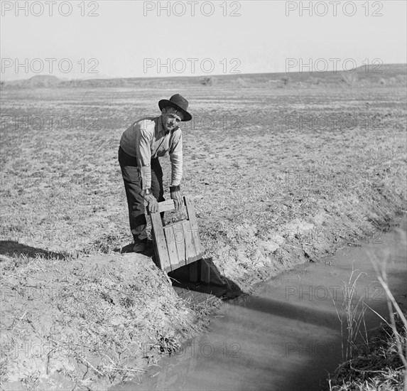 Farmer Opening Gate that Allows Water to Flow into Field from Irrigation Ditch, New Mexico, USA, Arthur Rothstein for Farm Security Administration (FSA), September 1936