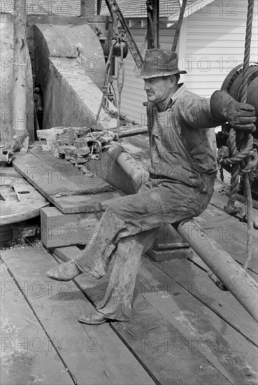 Oil Field Worker Resting on Length of Pipe, Kilgore, Texas, USA, Russell Lee, April 1939