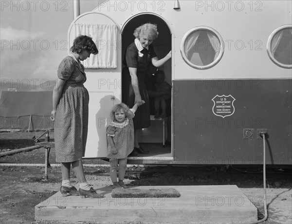Young Mother Bringing her Child to Trailer Clinic to be Examined by Doctor at Farm Security Administration Mobile Camp, Merrill, Klamath County, USA