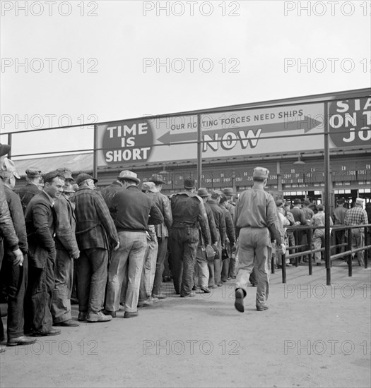 Workers Lining up Before Time Clock at Changing of Shifts, Bethlehem-Fairfield, Shipyards, Baltimore, Maryland, USA, Arthur S. Siegel for Office of War Information, May 1943