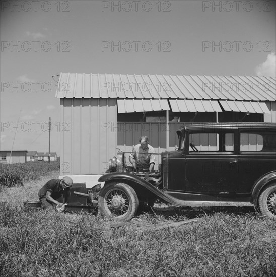 Migratory Workers Repairing Car Outside of their Shelter, Osceola Migratory Camp, Belle Glade, Florida, USA, Marion Post Wolcott for Farm Security Administration, June 1940