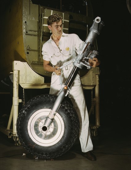 Worker Holding Nose Wheel and Landing Gear during Manufacturing of B-25 Bomber, North American Aviation, Inc, Inglewood, California, USA, Alfred T. Palmer for Office of War Information, October 1942