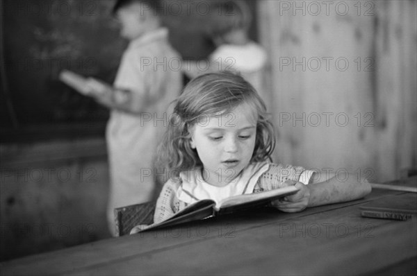 Young Girl Reading Book in Classroom, Cumberland Mountain Farms, near Scottsboro, Alabama, USA, Carl Mydans for U.S. Resettlement Administration, June 1936