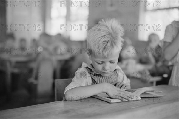 Young Boy Reading Book in Classroom, Cumberland Mountain Farms, near Scottsboro, Alabama, USA, Carl Mydans for U.S. Resettlement Administration, June 1936