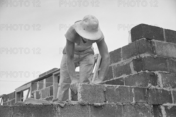Construction Worker Working with Cinder Blocks in Model Community Planned by Suburban Division of U.S. Resettlement Administration, Greenbelt, Maryland, USA, Carl Mydans for U.S. Resettlement Administration, August 1936