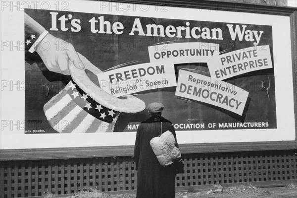 Man Standing in front of National Association of Managers Billboard, Dubuque, Iowa, USA, John Vachon for Farm Security Administration, April 1940